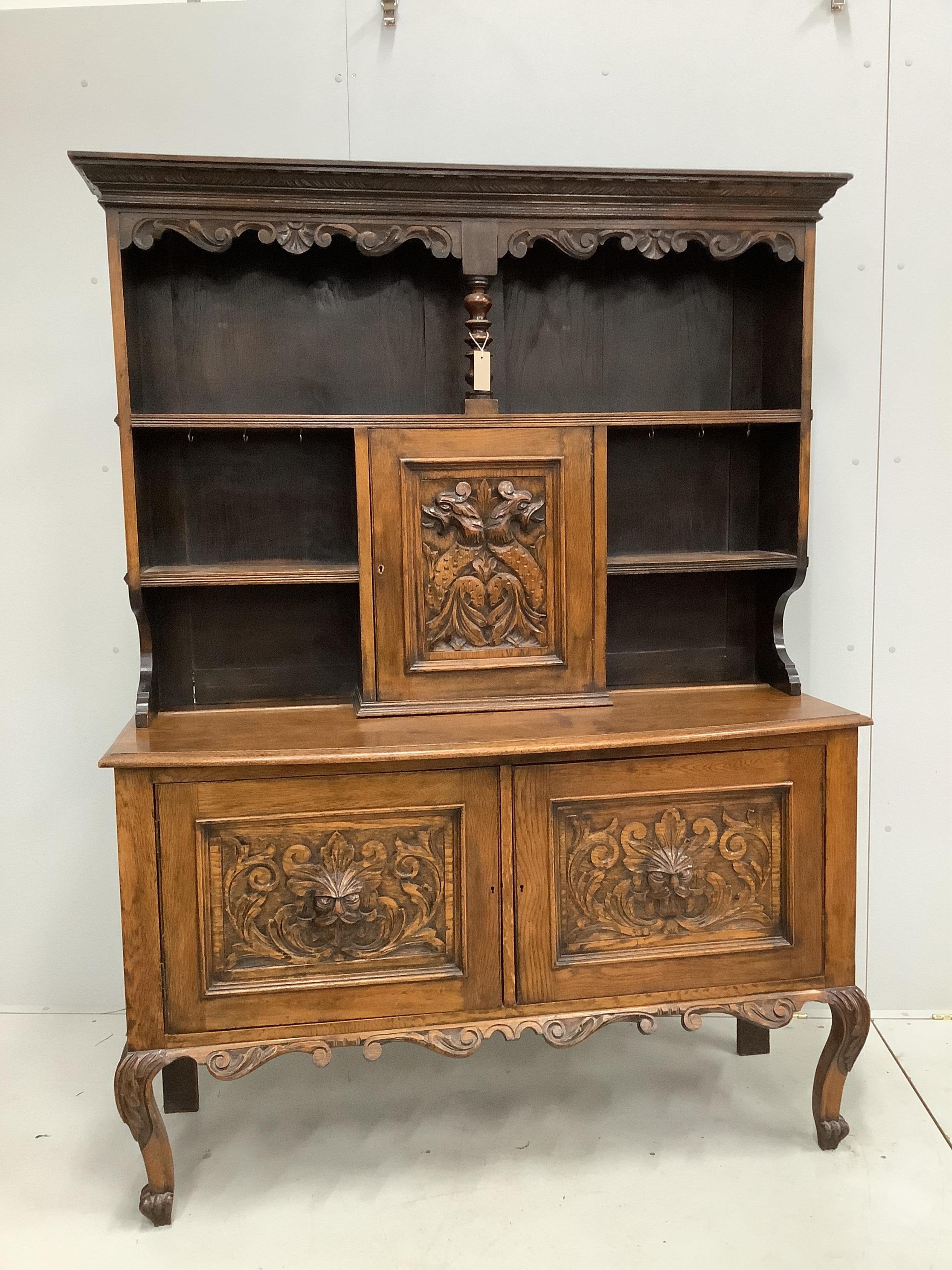 An early 20th century Flemish carved oak bow front dresser, width 138cm, depth 50cm, height 185cm